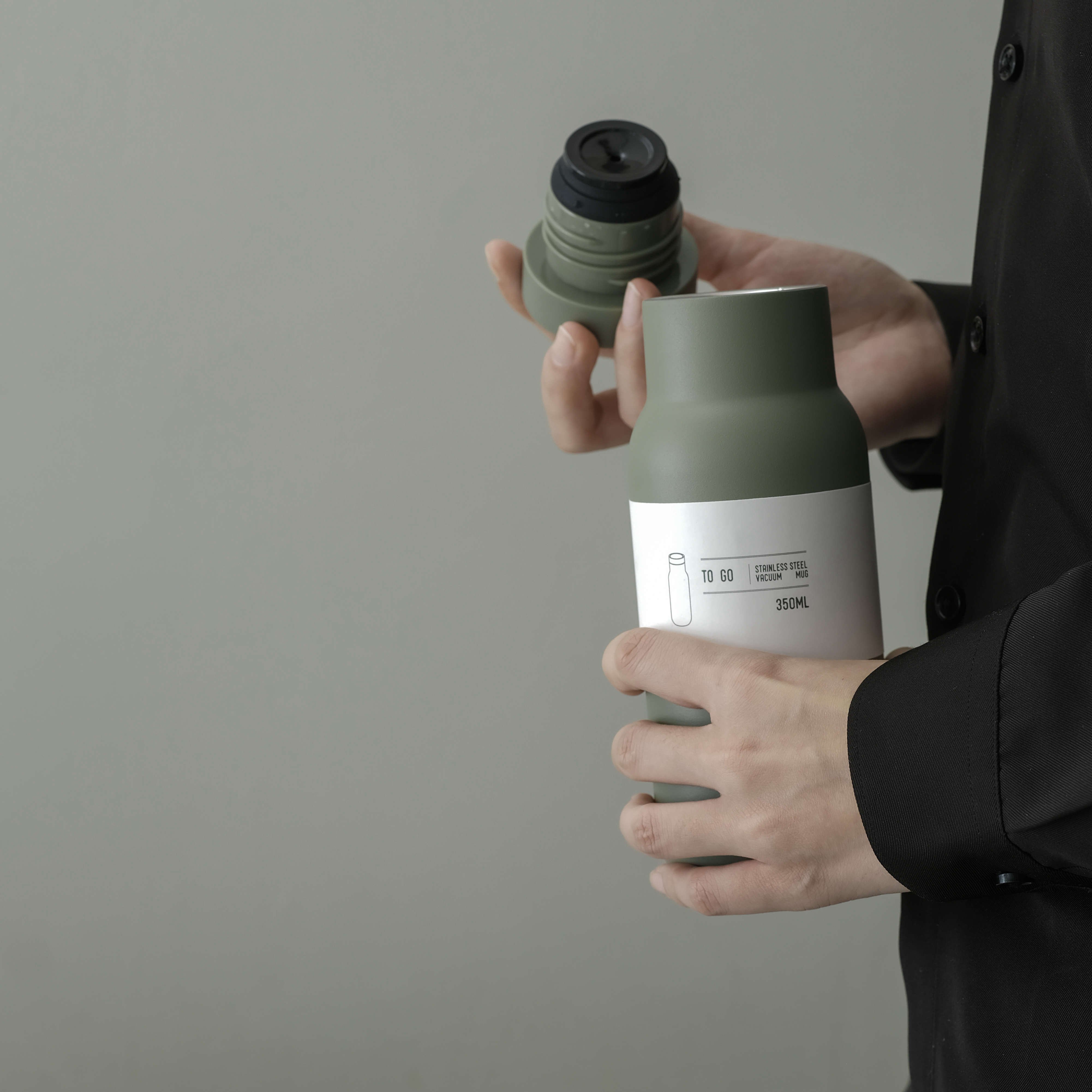 Matte green 500ml stainless steel vacuum bottle on a wooden desk, next to a laptop and a plant, showing compact daily use