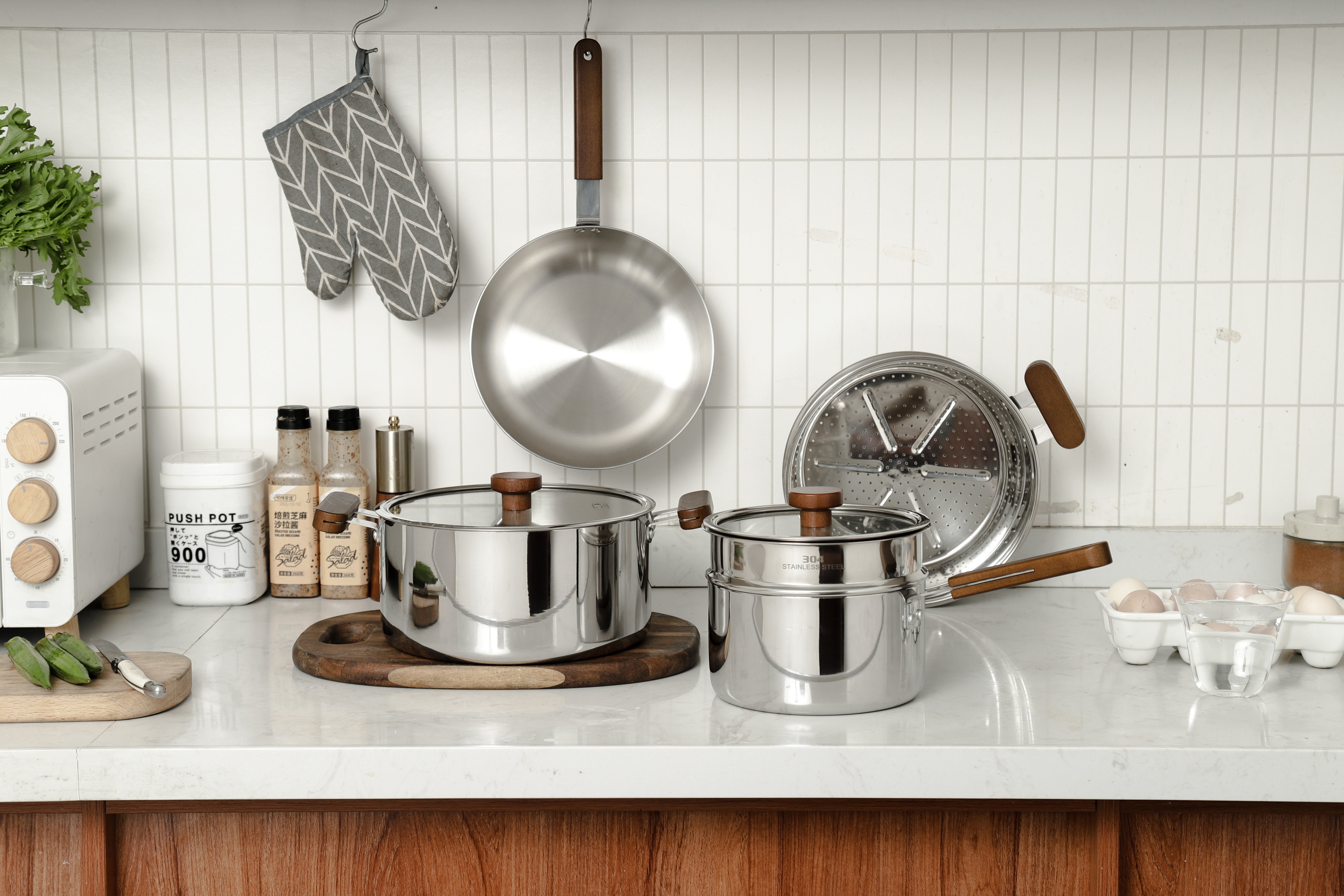 Stainless Steel Steamer Pot Set (3 - Layer) with Wooden Handles - Kitchen Countertop with Toaster, Spices, and Cooking Essentials, White Tiled Background